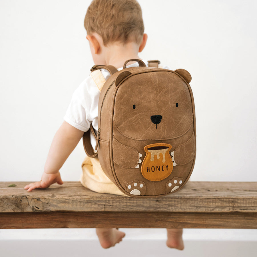 Rucksack für Kinder in braun in Form eines Bärs mit einem kleinen Honigtopf in den Händen