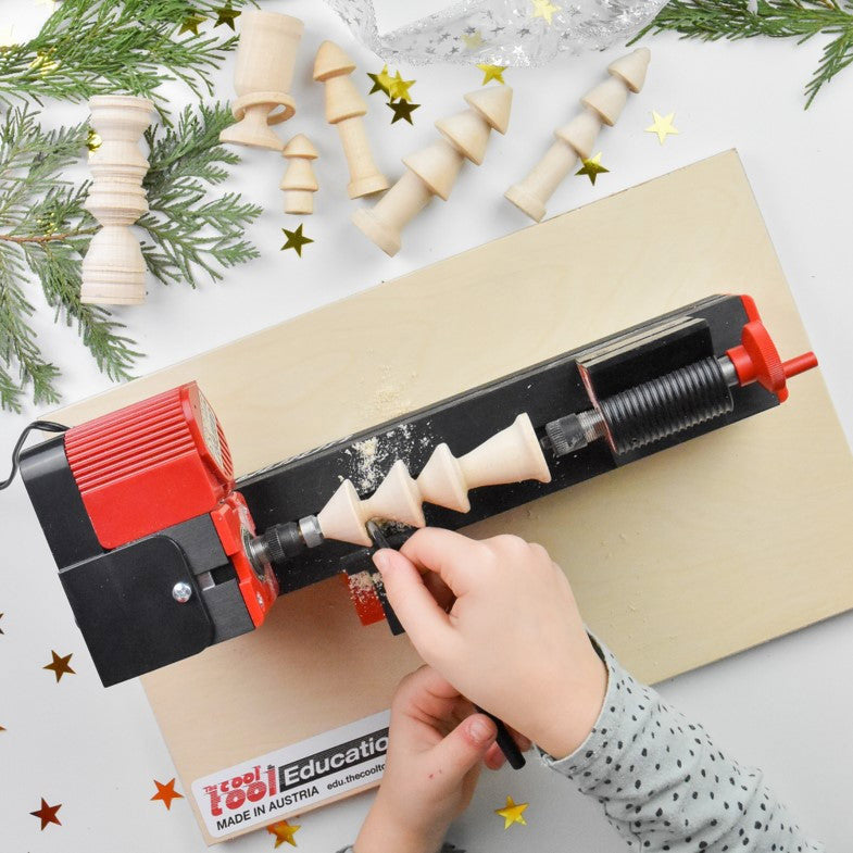 Kind fertigt am MultiTool einen Tannenbaum aus Holz