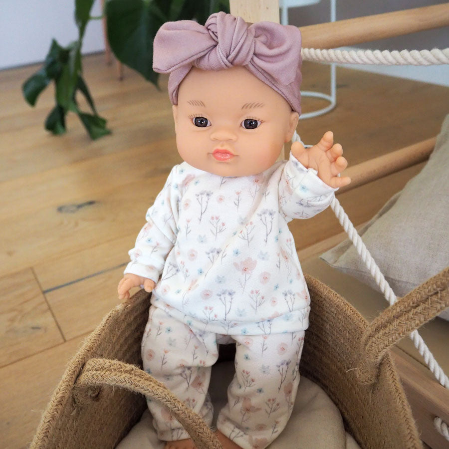 Die Puppe Gordi Alessandra hat einen asiatischen Look und trägt einen Zweiteiler in weiß mit zarten Blumen